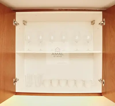 a glass display case with glasses on a shelf at Modern 1BR theme and Burj Khalifa View Downtown in Dubai