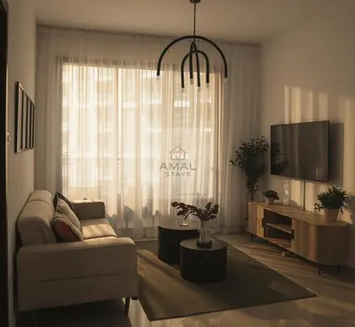 a living room with a couch and a tv at Modern 1BR theme and Burj Khalifa View Downtown in Dubai