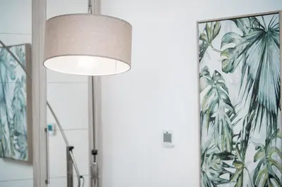a floor lamp in a room with a tropical mural at HiGuests - Charming Studio with Lake Views in Business Bay in Dubai