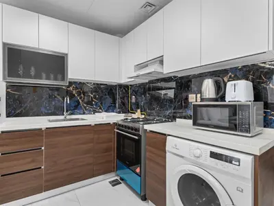 a kitchen with a washing machine and a washer at Luxurious Haven Studio In Jewelz Arjan 03 in Dubai