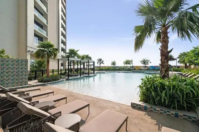 a pool at a resort with chairs and palm trees at Luxury Studio With Pool View Near Burj Khalifa in Dubai