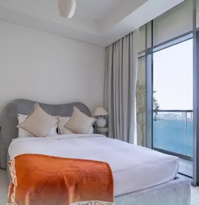 a bedroom with a large bed and a large window at Luxury Studio With Pool View Near Burj Khalifa in Dubai