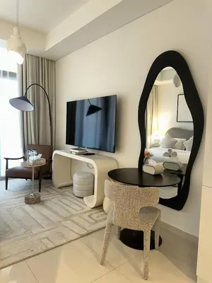 a living room with a large mirror and a tv at Luxury Studio With Pool View Near Burj Khalifa in Dubai