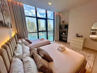 a living room with a couch and a large window at Modern 2-Bedrooms Apartment with Stunning Marina Views in Dubai