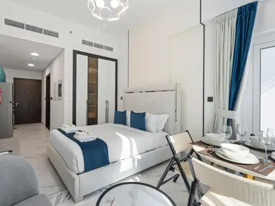 a bedroom with a large bed and a dining room at Opalz Reverie Luxe Studio Escape 08 in Dubai