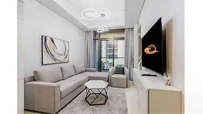 a living room with a couch and a tv at Modern Luxury Stylish 2BR Near Downtown Aykon C in Dubai
