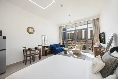 a bedroom with a bed and a living room at Daniels Studio at V2 Residence, Sports City in Dubai