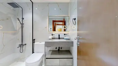a bathroom with a sink and a toilet and a mirror at Marina View Tower 2BR Stunning Canal Views in Dubai