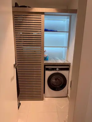 a washer and dryer in a room with a door at La Mer Iconic View 1 bedroom in Dubai