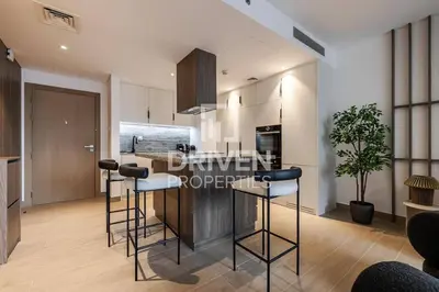 a kitchen with a bar with stools in it at La Mer Iconic View 1 bedroom in Dubai