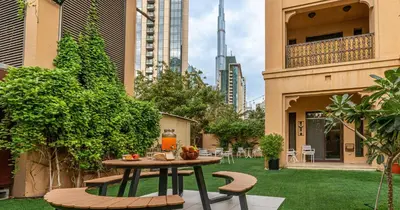 a patio with a table and chairs in a courtyard at Downtown 2BHK Burj View & Private Garden in Dubai