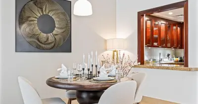 a dining room with a table with chairs and a mirror at Downtown 2BHK Burj View & Private Garden in Dubai