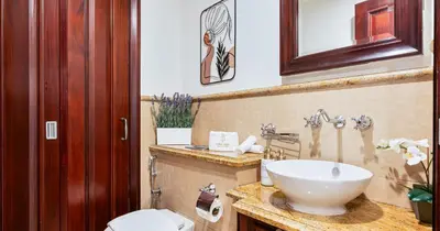 a bathroom with a white sink and a toilet at Downtown 2BHK Burj View & Private Garden in Dubai