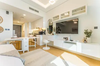 a white kitchen with a desk and a sink at Inviting Studio Overlooking the Pool, Just a Short Drive from Dubai Autodrome, Samana Golf Avenue, Dubai Studio City by Deluxe Holiday Homes in Dubai