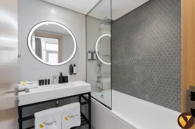 a bathroom with a sink and a mirror at Vogue JVT Novotel near Springs Souk Mall, One Bedroom apartment with Balcony and Vibrant Community View, Access to all Amenities in Dubai