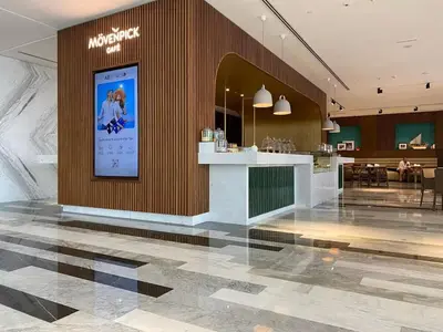 a lobby with a counter with a poster on the wall at Vogue JVT Novotel near Springs Souk Mall, Studio Apartment with Balcony and City View, Access to all Amenities in Dubai