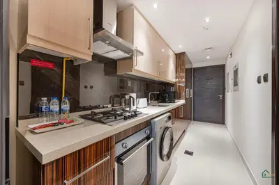 a kitchen with wooden cabinets and a stove top oven at Luxury Studio Retreat! Heart of Downtown Dubai! in Sabkhah