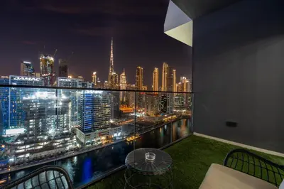 a room with a view of a city at night at GuestReady - Studio l Partial Burj Khalifa View in Dubai