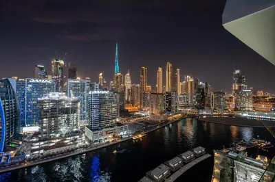 a view of a city at night with at GuestReady - Studio l Partial Burj Khalifa View in Dubai