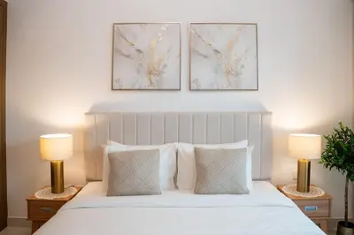 a bedroom with a white bed with two lamps at Airstay - Stylish Studio - Spacious Balcony - Monthly Offer Available! in Dubai