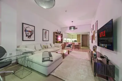 a living room with a white couch and a glass table at Trendy Marina 2-Bedroom Apartment in Dubai