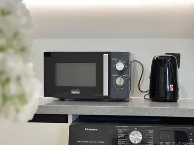 a microwave oven sitting on top of a counter at Fresh and Modern 1BR Welcome to Asak 11 JVC in Dubai