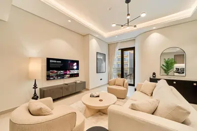 a living room with a couch and a tv at Fresh and Modern 1BR Welcome to Asak 11 JVC in Dubai
