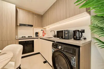 a kitchen with a washer and a dishwasher at Fresh and Modern 1BR Welcome to Asak 11 JVC in Dubai