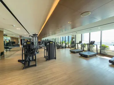 a gym with treadmills and exercise equipment in a building at Private Jacuzzi Canal view - Near Burj Khalifa in Dubai