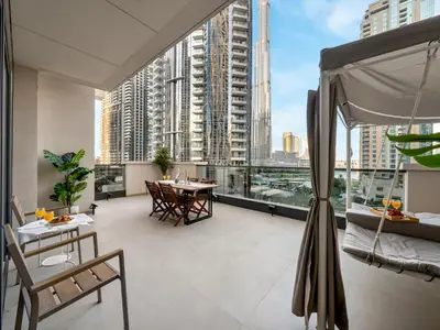 a room with a balcony with a table and chairs at 2BDR - Burj Khalifa view with Private terrace in Dubai