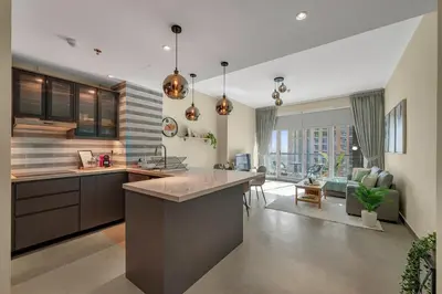 a kitchen and living room with a couch and a table at The Torch Cozy 1BR Marina Near JBR & Metro in Dubai