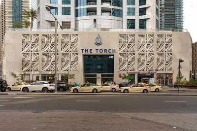 a group of cars parked in front of a building at The Torch Cozy 1BR Marina Near JBR & Metro in Dubai