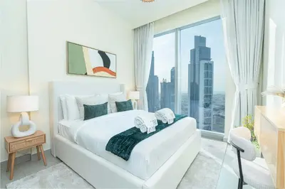 a bedroom with a white bed and a large window at PVH - Contemporary 1BR Near Burj Khalifa - Forte Tower 2 in Dubai