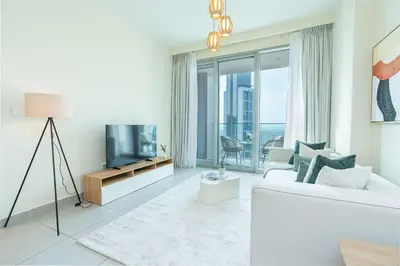 a living room with a white couch and a tv at PVH - Contemporary 1BR Near Burj Khalifa - Forte Tower 2 in Dubai