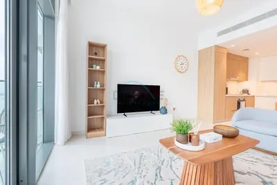 a living room with a tv and a table at Stunning View, Easy Access to Dubai Attraction, Beach Vista Tower 2, Emaar Beachfront by Deluxe Holiday Homes in Dubai