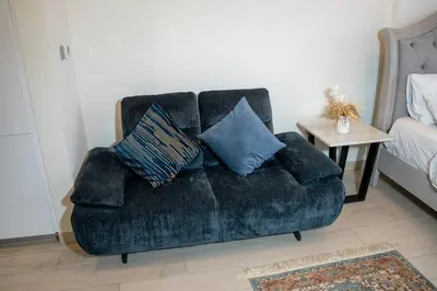 a blue couch with pillows on it in a room at Burj Khalifa View Studio 10 mins away Dubai Mall in Dubai