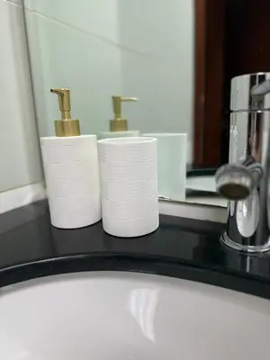a bathroom counter with three rolls of toilet paper in front of a mirror at Spacious 1Bed with Golf Course and Marina View in Dubai