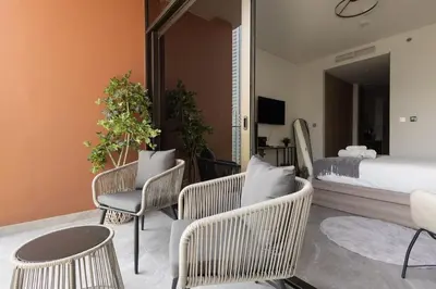 a bedroom with wicker chairs and a bed and a table at Cozy studio with Burj Khalifa and canal view in Dubai