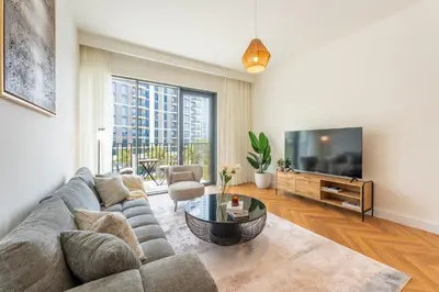 a living room with a couch and a tv at ShoresInn - Luxury Dubai Creek Harbour Stay in Dubai