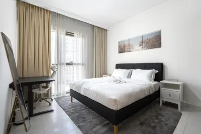 a bedroom with a bed and a desk in it at Spacious 1BR in Creek Harbour with Gym and Pool in Dubai