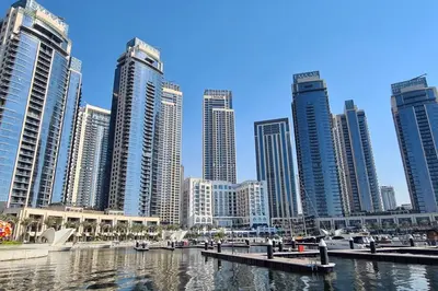 a city with tall buildings and a river with boats at Spacious 1BR in Creek Harbour with Gym and Pool in Dubai