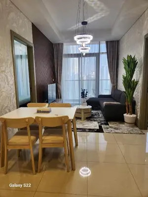 a living room with a table and chairs and a couch at Majestic Canal View 2Bhk 6pax in Dubai