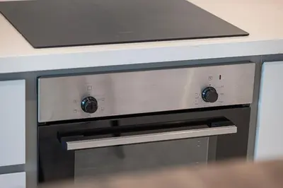 a stove top oven sitting under a counter at 2 Bedroom Apartment in Emaar Beachfront with Palm and Marina Views in Dubai