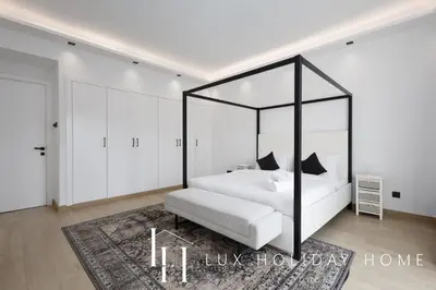a bedroom with a white bed with a black canopy at LUX The Serene Springs Villa in Dubai