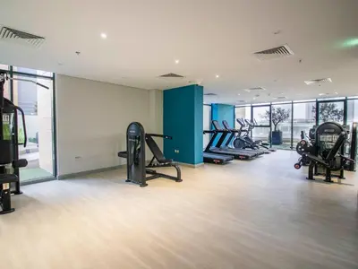 a gym with several treadmills and elliptical machines at Elegant 2BR Getaway in Azizi Riviera Near Downtown in Dubai