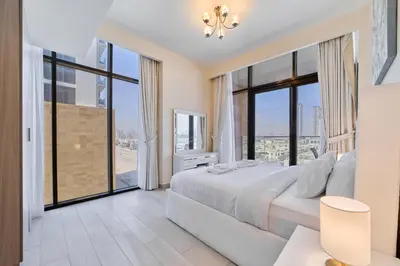 a bedroom with a large bed and large windows at Elegant 2BR Getaway in Azizi Riviera Near Downtown in Dubai