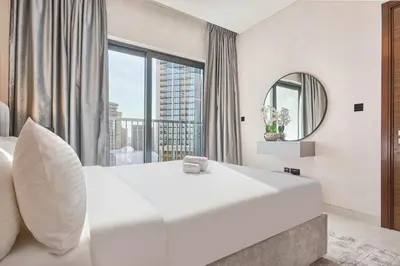 a bedroom with a large white bed and a large window at STAY BY LATINEM Luxury 1BR Holiday Home CA 1605 Near Burj Khalifa in Dubai