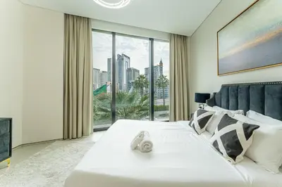 a bedroom with a white bed with a large window at HAVN - 3 Bedroom in The Address, JBR in Dubai