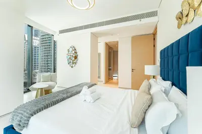 a bedroom with a large white bed with a blue headboard at HAVN - 3 Bedroom in The Address, JBR in Dubai
