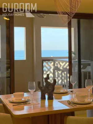 a dining room table with glasses and a view of the ocean at Amazing 4 BR on Palm Jumeirah with super sea view in Dubai